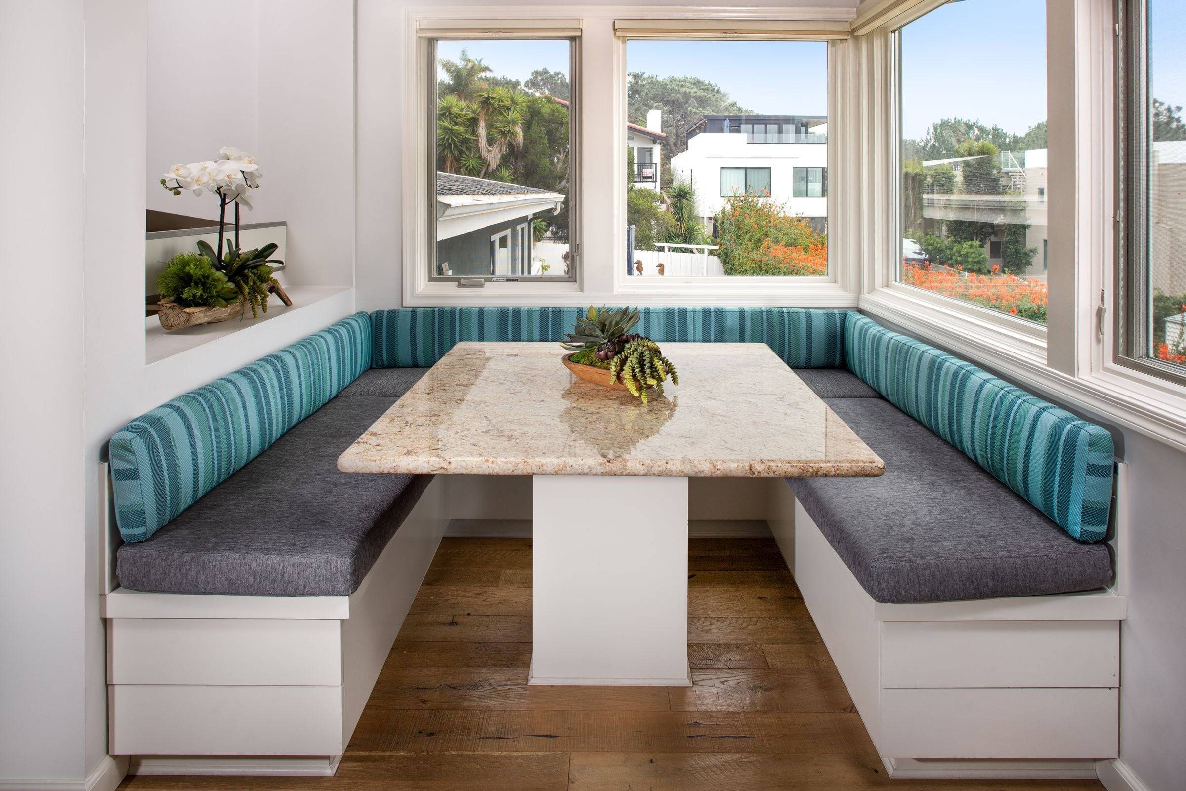Banquette d’angle à coffres sous des fenêtres.